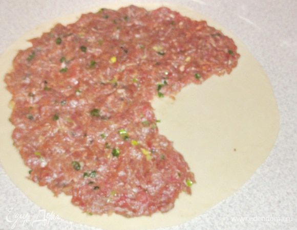 Каждую часть теста раскатайте в лепешку диаметром примерно  22-23 см. На нее распределите тесто закрыв 3/4  части лепешки.