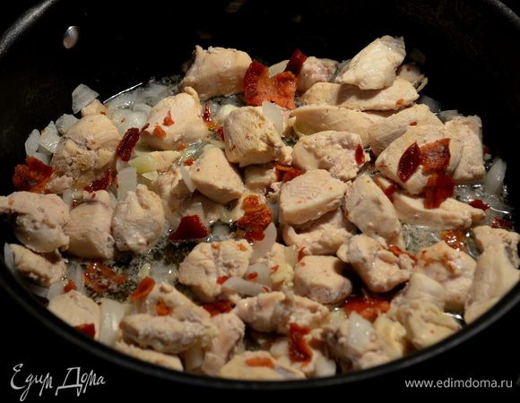 Добавим кусочки курицы на эту же сковороду,увеличим огонь на высоко -сред. и обжариваем примерно 2мин.Добавим лук,готовим еще 2мин.Затем чеснок.Готовим 1мин.или до окончания как кусочки курин.будут готовы.Снимем с огня и добавим поломанный бекон половину.