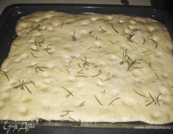 Делаем пальцем углубления в тесте. Смешиваем 1 ст.л оливкового масла, 1 ст.ложку воды и обмазываем тесто. Посыпаем крупной морской солью и веточками розмарина. Выпекаем 20-25 минут при темп. 200гр.