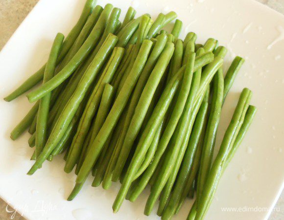 Отварите фасоль в течении 6 мин, обдайте холодной водой. Если стручки целые, нарежьте их на 2-3 части.Помидоры разрежьте, удалите семена и нарежьте кубиками. Смешайте с фасолью и полейте французской заправкой. Подавайте на тарелке вместе с бараниной и долькой лимона.