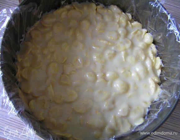 Разъемную форму для торта застелить пищевой пленкой. Выложить шоколадно-кукурузную массу, разровнять. Убрать в холодильник.