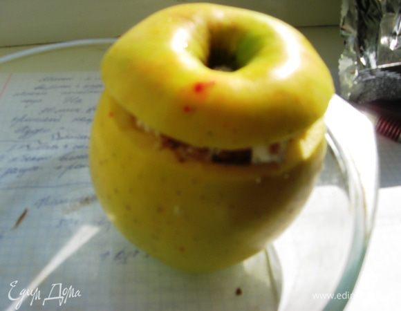 Закрываем их шапочкой. Духовку разогреваем до 180 градусов. Чтобы яблочки не сморщились, мякоть в некоторых местах протыкаем вилочкой. В форму наливаем пару столовых ложек воды. Кладем яблочки и выпекаем 30 минут. 