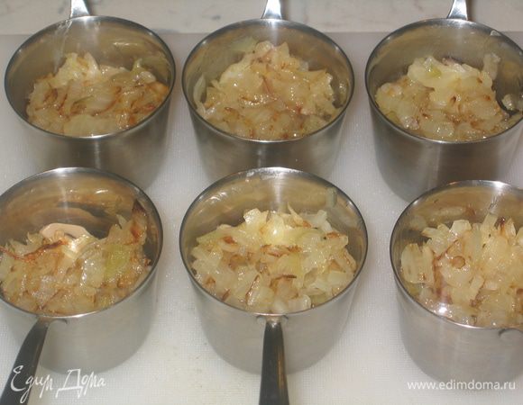 В кокотницы выложить по 1-2 ст.л. грибов и добавить 1 ст.л. поджаренного лука