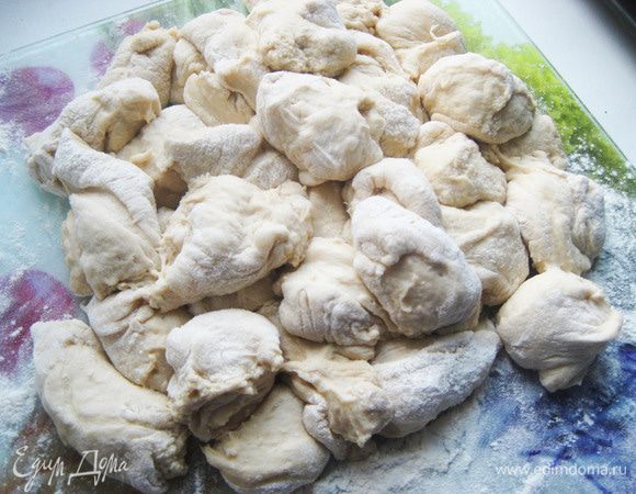 Берем наше выросшее тесто, выкладываем на доску, присыпанную  мукой, рубим  на полосы, а полосы на кусочки. 