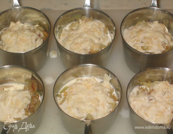 Поверх лука налить соус (1-2 ст.л.) и посыпать тертым сыром (1/2 часть)