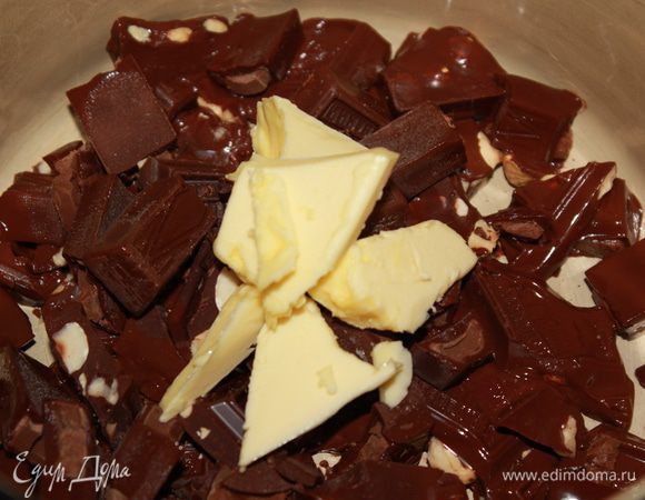 На водяной бане растопить шоколад, добавив кусочек сливочного масла. Влить сливки, прогреть и снять с огня.
