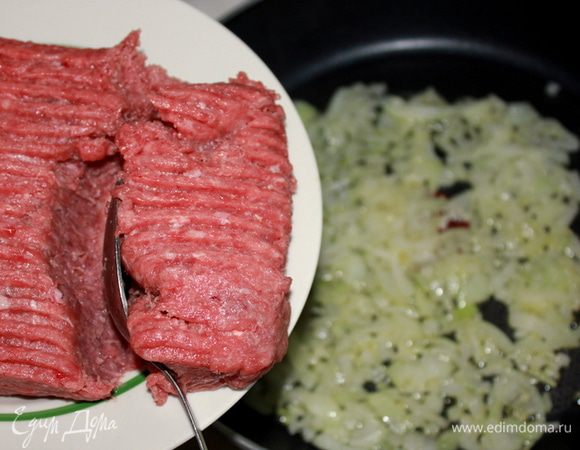 Лук почистить, мелко порезать, пассеровать на сковороде в разогретом оливковом масле до мягкости. Добавить мясной фарш, посолить, поперчить. 