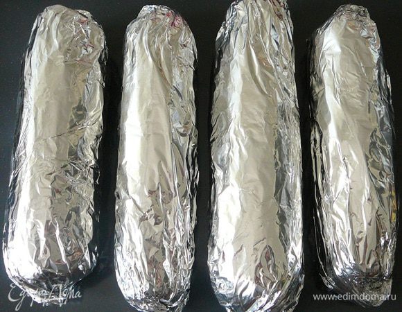 Плотно завернуть каждый початок в фольгу  запекать в духовке 40 минут. Таким же образом можно запечь кукурузу на костре или в горячих углях на пикнике...