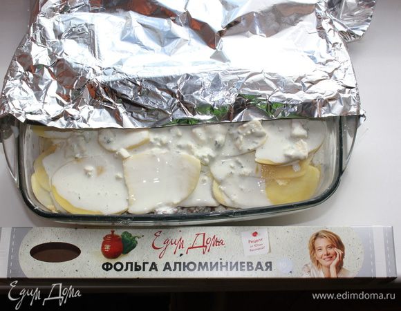 Накрыть форму фольгой - матовой стороной наверх, блестящей - внутрь. Матовая сторона притягивает тепло, а блестящая его отражает. Поставить в разогретую до 200 градусов духовку на 30 минут (на верхний уровень). 