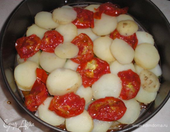 Выкладываем нарезанный кружочками картофель, в промежутки выкладываем помидоры.





