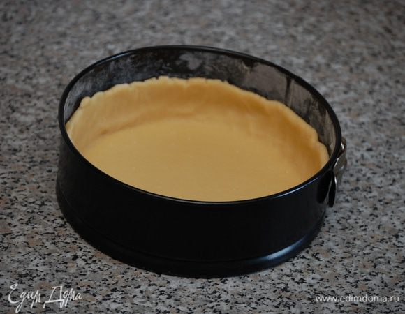 Охлаждённое тесто раскатать на присыпанной мукой поверхности в круглый пласт толщиной 5-6мм. и выложить в форму ровным слоем.