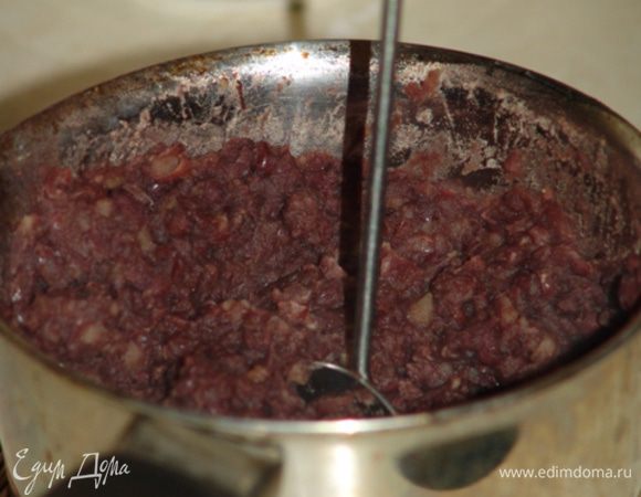 Когда фасоль будет очень мягкой, сливаем оставшуюся воду - в отдельную посуду, но не выливаем. Отложим небольшую горсть фасоли в в сторону, а остальную массу давим толкушкой. Получится пюре, в которое нужно добавить отложенные цельные бобы, и все тщательно перемешать. После перемещаем всю массу обратно в кастрюлю и продолжаем варить на маленьком огне в течение 10-15 минут до тех пор, пока бобовая масса не приобретет темно-коричневый или темно-бордовый цвет. Если в процессе варки пюре станет слишком густым, добавляем предварительно слитый бульон. 