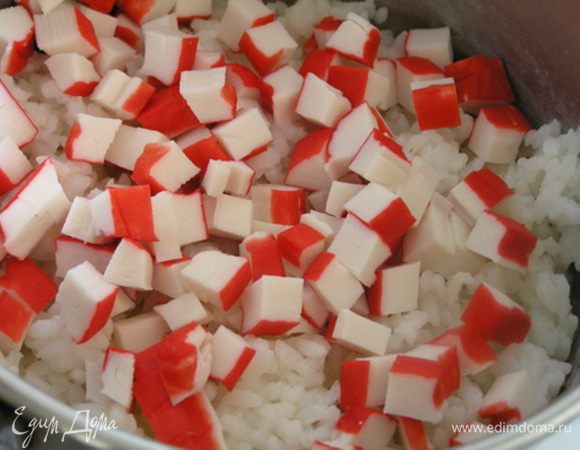 Рис смешайте с нарезанными крабовыми палочками.