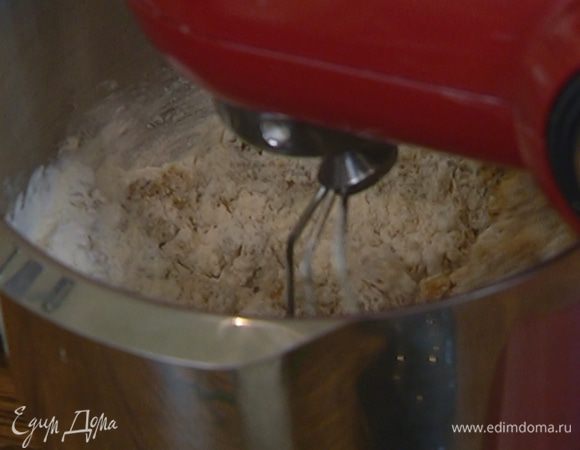 Не выключая комбайна, порциями ввести муку с разрыхлителем.