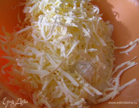 Чуть позже приготовить тесто. Для этого муку высыпать в миску, смешать с солью и содой, добавить натертый на терке маргарин и растереть все руками.