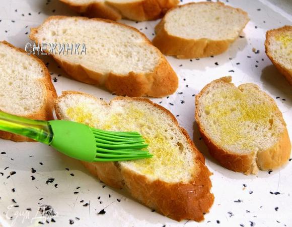 Для кростини багет нарезаем ломтиками. Слегка смазываем оливковым маслом. Подрумяниваем в духовке при 190С.