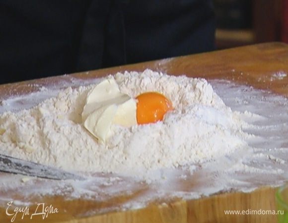 Сделать из муки с маслом холмик с углублением, выложить в центр сметану и желток и очень быстро порубить ножом.