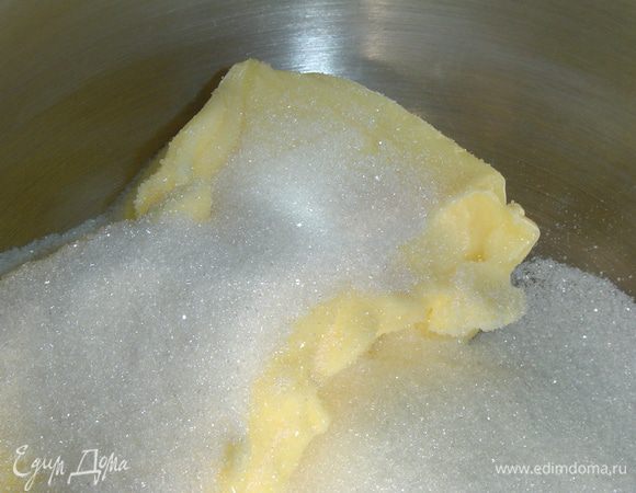 Начинка готова, и мы приступаем к приготовлению коржей. Размягченное масло взбиваем до бела с сахаром, а затем по одному добавляем яйца и взбиваем до однородного состояния.