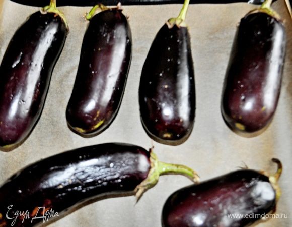 Разогреть духовку до 180С.
Баклажаны вымыть, вытереть насухо.
Проколоть баклажаны вилкой в нескольких местах и смазать раст.маслом.
Противень застелить фольгой или бумагой для выпечки,уложить на противень баклажаны и запечь до мягкости, примерно 25-30 минут (зависит от Вашей духовки).