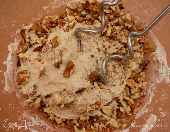 В конце замеса добавить орехи и продолжать месить, пока они не распределятся равномерно...