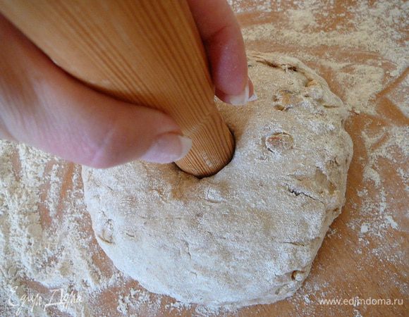 Поставить конец скалки в середину шара и, аккуратно надавливая, проделать сквозное отверстие. 