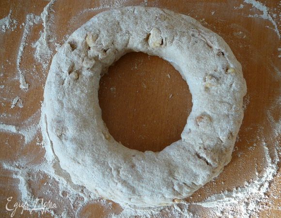 Слегка присыпать руки мукой и осторожно расширить отверстие так, чтобы получилось кольцо. Отверстие должно быть размером, как минимум, с кулак, иначе оно затянется во время расстойки.
