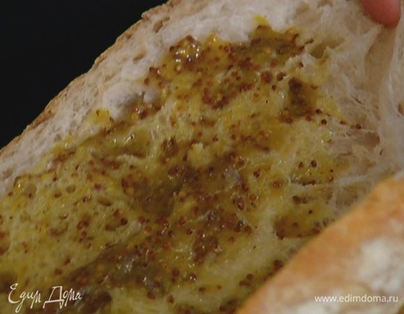 Хлеб разрезать сбоку вдоль пополам, не прорезая до конца, развернуть и смазать обе половины заправкой.