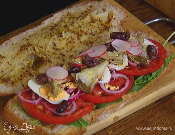 На одну половину хлеба слоями выложить руколу, нарезанные помидоры, редиску, лук, яйцо, артишоки и оливки.