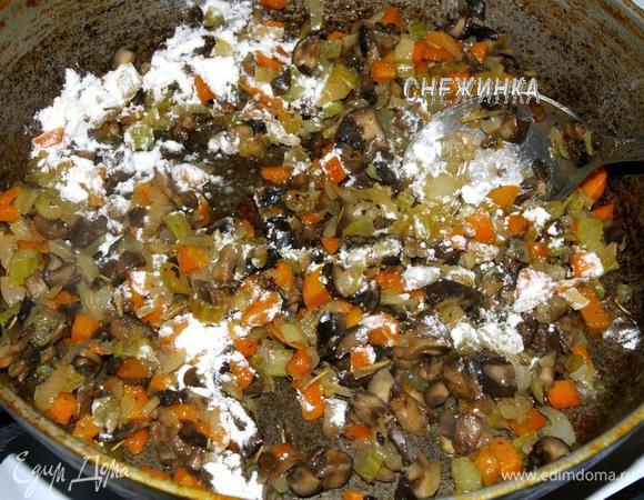 Добавляем грибы и жарим еще 5 минут. Всыпаем муку и помешиваем минуту.