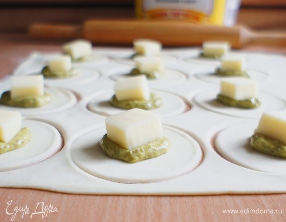 На каждый кружочек теста положить по 1 ч.л. песто и кусочек сыра.