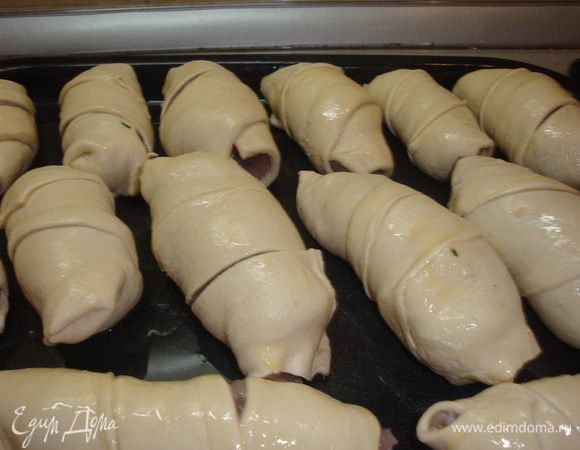 Затем раскатонное слоеное тесто режим на полоски шириной примерно 4-5 см. Заворачиваем рулеты в слойку по спирали, смазываем взбитым яйцом и ставим в духовку выпекать на 35-40 минут при температуре 180 гр.