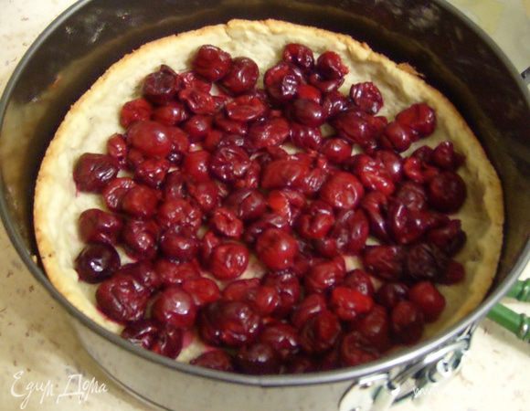 Выложить вишни на песочный корж. Если используете замороженную вишню, ее предварительно нужно разморозить, слить всю жидкость, а корж посыпать вначале крахмалом (1-2 ст.л.), а затем выкладывать вишню.