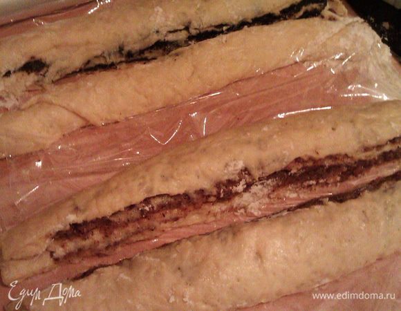 Разрезаем каждый рулет вдоль пополам острым ножом, обваленным в муке, слегка отодвигая половинки друг от друга. Если нож плохо идет по тесту, постоянно окунайте его в муку.