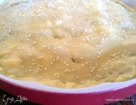 Затем раскатываем второй кусок теста и накрываем им овощи, таким образом формируя пирог. Защипываем края и в нескольких местах прокалываем пирог вилкой. Пирог смазываем взбитым яйцом и посыпаем кунжутом.
Выпекаем пирог при температуре 200С  25-30 минут, до золотистой корочки.