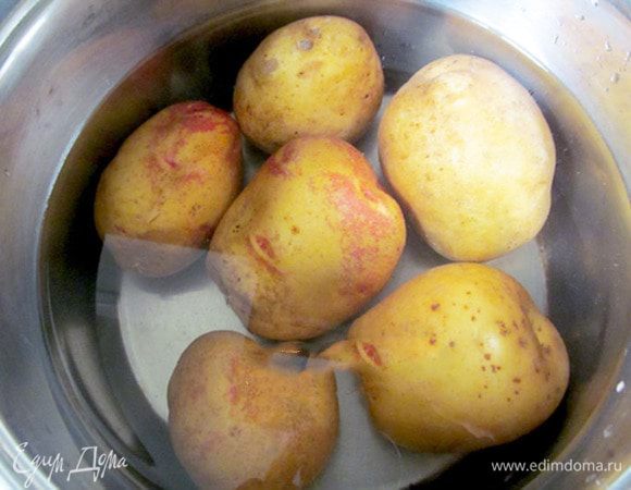 В очищенной картошке делаем углубления. Сейчас у меня есть специальный нож, но когда я готовила это блюдо, ножа еще не было. Я вынимала мякоть чайной ложкой. Лучше не прорезать сквозное отверстие, оставить донышко. Но это не принципиально.
