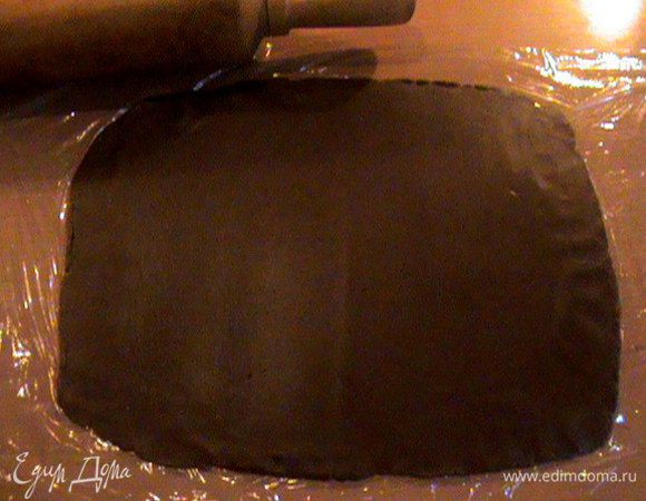 Раскатать шоколадный шар в прямоугольник толщиной 2-3мм. Удобнее всего раскатывать это тесто между пищевой плёнкой. Так оно не прилипает к скалке.