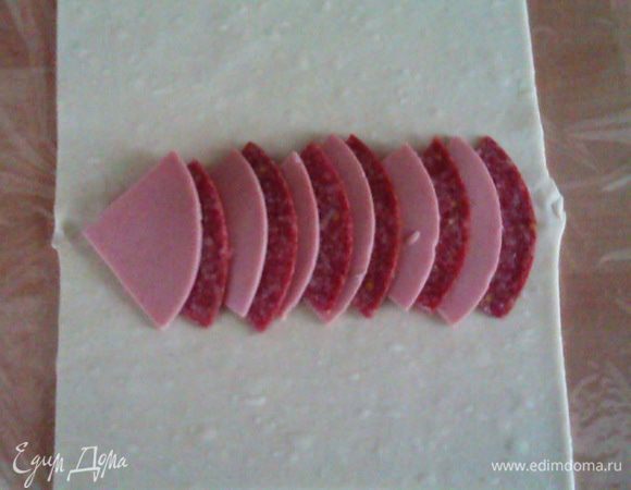 Выкладываем по центру теста, чередуя ветчину и салями.