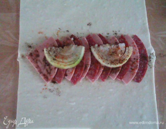 Разрезаем срез лука пополам, выкладываем сверху, посыпаем черным перцем и паприкой.