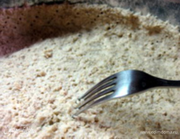 Достать форму с тестом из холодильника и часто наколоть тесто вилкой, затем поставить запекать в духовку на 15 минут.