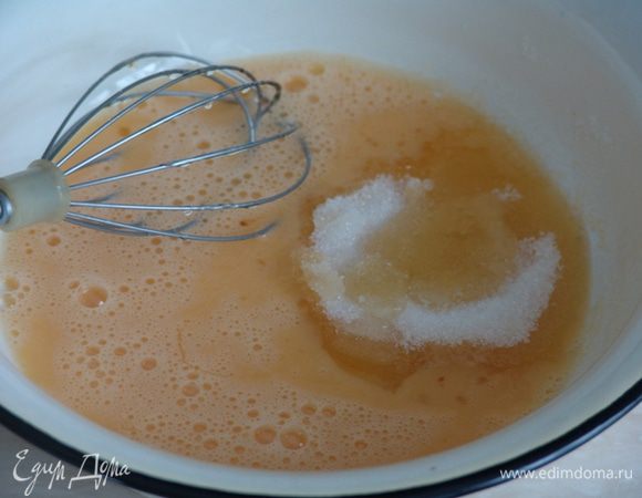 Готовим тесто: разбиваем яйца, слегка взбиваем венчиком. Добавляем сахар и мед. Мед должен быть жидким. Взбиваем смесь около 3 мин. Растворяем соду в 50 мл воды, добавляем в смесь. Добавляем просеянную муку и размешиваем тесто. Накрываем миску пищевой пленкой и оставляем на 30 мин.