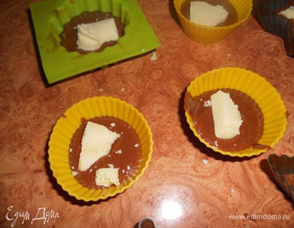 формы на половину наполнить тестом,сверху положить по ломтику белого пористого шоколада