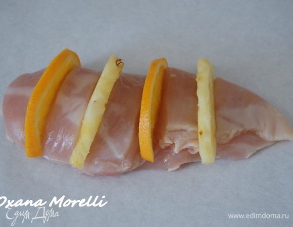 Каждую грудку выложить на лист бумаги для выпечки, предварительно  смоченный в воде и отжатый,  и начинить поочередно дольками апельсина и ананаса.