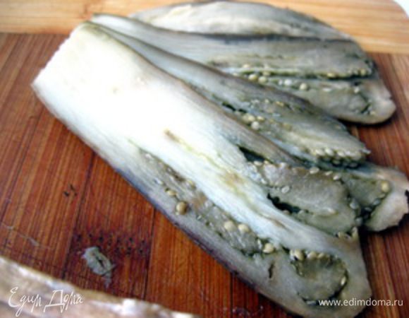 Затем баклажан очистить от кожицы и нарезать тонкими пластинками. Смазать каждую пластинку пропущенным через пресс чесноком и оставить баклажаны пропитываться его ароматом.