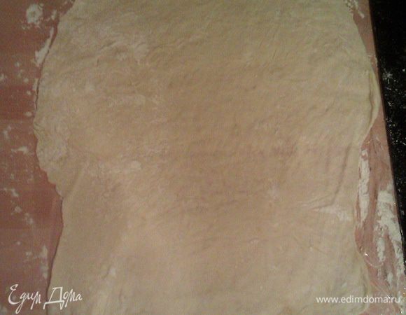 Очень тонко раскатываем тесто на пленке (в рецепте от бабушек, конечно же, на полотенце), слегка смазываем сливочным маслом.
