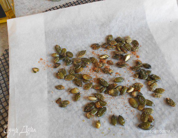 В миске встряхнуть тыквенные семена с маслом, чесноком, корицей и перцем ( если используете 2 последних).
Поместить  всё на бумагу для выпечки от "HQC" и обжарить на нижнем уровне духовки 5 мин.( Может потребоваться меньше времени. Вы услышите, как будут трещать семена). Достаньте их и отложите в сторону.
