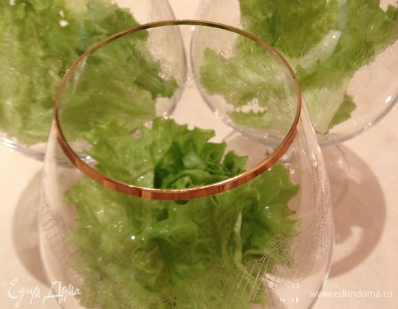 Положить листья салата на дно бокала