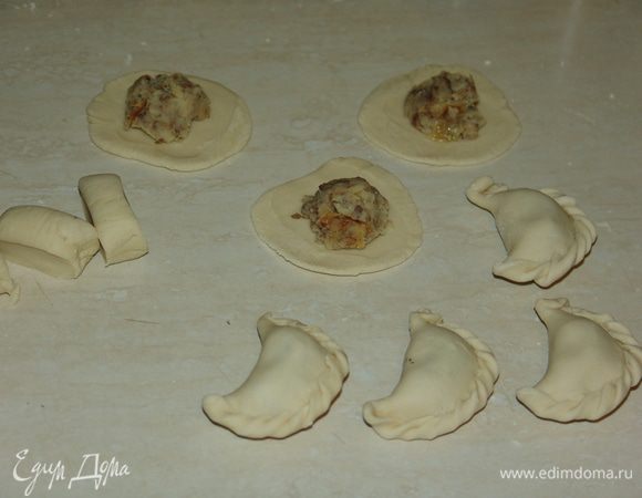От готового теста отрезаем четверть, скатываем колбаску, нарезаем на равные кусочки. Оставшееся тесто оборачиваем в пленку, чтобы не обветрилось. Раскатываем тесто в кружки, выкладываем начинку. Края вареника тщательно защипываем. 