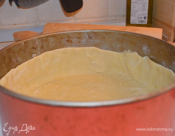 Тесто достать, раскатать в очень тонкий пласт - примерно 0,4 см и перенести в смазанную сливочным маслом форму (24 см, разъемная). Распределить по ней, сделав очень высокие бортики примерно 6-7 см. Потыкать вилкой везде и отправить в духовку, разогретую до 220 градусов на 10 минут.
