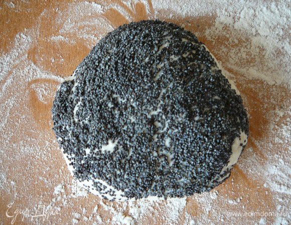 Шарик теста слегка расплющить, окунуть одной стороной в воду, сразу после этого - в мак. Вдавить семена в тесто.