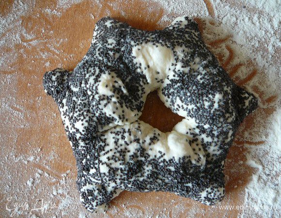 Взять булку в руку и аккуратно "вывернуть " ее наизнанку через разрезы. Теперь внутренние углы станут  внешними концами звезды. Оставить булки на расстойку на 45 минут. Поставить противень в разогретую духовку, обрызгать стенки из пульверизатора водой. Выпекать 10-12 минут.